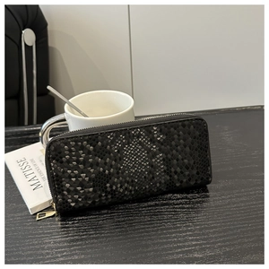Gros plan détaillé d'un portefeuille long en cuir noir à relief serpent et zip doré