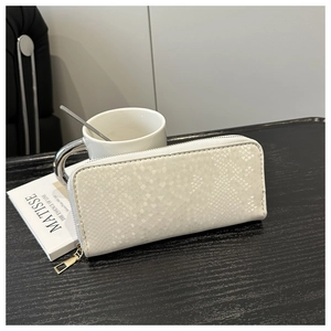 Gros plan sur un long portefeuille blanc avec texture serpent et zip doré chic