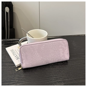 Détail du portefeuille long lilas à texture serpent avec fermeture éclair dorée chic