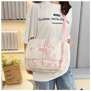 Détail du sac messager crème avec imprimés papillons roses et bandoulière réglable sur modèle