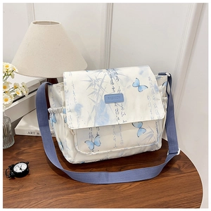 Détail du sac bandoulière avec motifs papillons, rabat et sangle bleue réglable