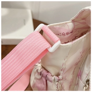 Détail de la sangle en nylon rose et boucle en plastique sur sac en tissu à calligraphie