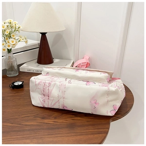 Détail du sac bandoulière blanc en nylon avec motif papillon rose et bambou sur bureau