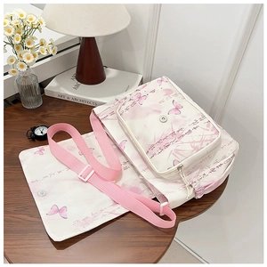 Détail du sac bandoulière en toile avec motif papillon rose et petite pochette