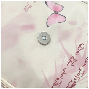 Vue macro du fermoir magnétique avec motifs de papillons roses et calligraphie d'art