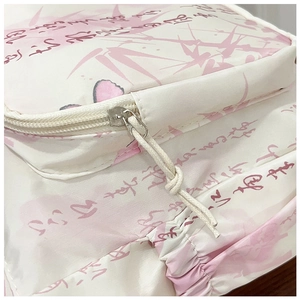 Détail d'un sac en toile blanche avec imprimés bambou rose et fermeture à glissière tressée