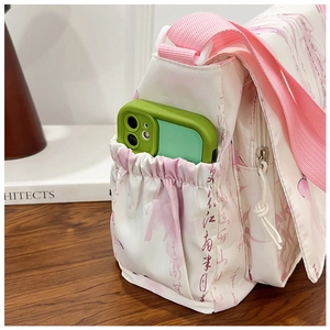 Détail de la poche latérale d'un sac bandoulière contenant un téléphone portable