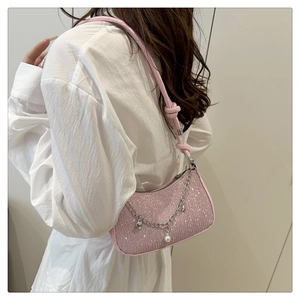 Détail du sac sous le bras à paillettes roses avec chaîne argentée et perles