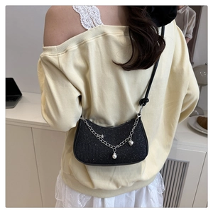 Détail du sac croissant noir scintillant avec étoiles argentées et breloques perles