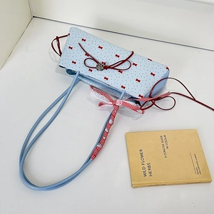 Hellblaue Schultertasche aus Kunstleder mit roten Schleifenprints und Spitzenriemen
