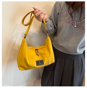 Detail of yellow canvas hobo bag with adjustable strap and front FANYISSA brand label