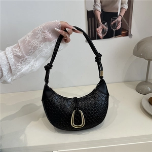 Chic black woven crescent shoulder bag with golden horseshoe buckle and knotted handle