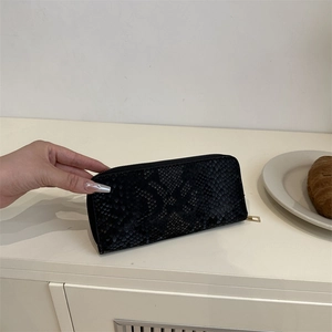 Portefeuille femme noir à motif serpent avec fermeture éclair dorée et cuir texturé