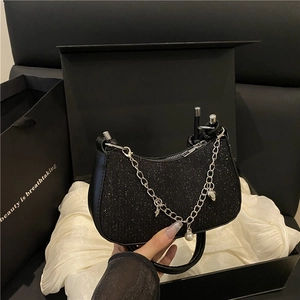 Sac sous le bras noir scintillant avec breloques argentées sur boîte cadeau