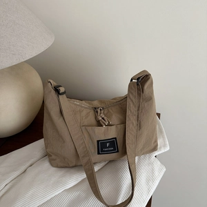 Minimalist khaki canvas shoulder bag for women with adjustable strap and logo detail