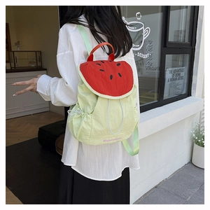 Outdoor view of watermelon-shaped backpack with red fruit pattern and green nylon fabric