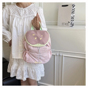 Close-up of pink and purple contrast nylon backpack with Guava print and side drawstrings