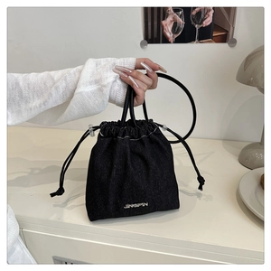Détail du sac seau en denim noir avec logo JINGPIN dans un cadre de vie quotidien