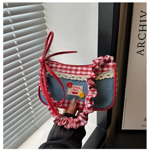 Detail of sweet bow hobo bag with lace trim, cherry patch, and ruffled denim fabric
