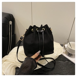 Close-up of black drawstring bucket bag with gold eyelets and matte finish texture