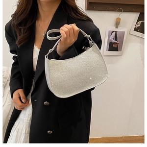 Close-up of sparkling silver rhinestone hobo bag worn on the shoulder by a model