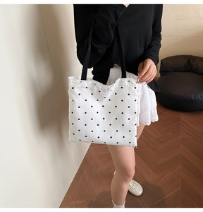 Detailed shot of white canvas tote bag with black star prints and lace trim edge