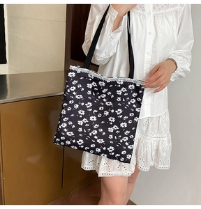 Close-up of floral canvas tote bag with delicate lace trim on the shoulder strap