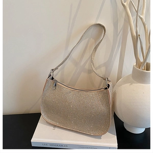Close-up of champagne gold rhinestone shoulder bag with shimmering crystal texture