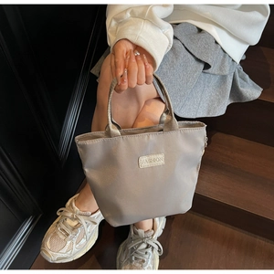 Détail du mini sac cabas gris en nylon avec étiquette Fashion dans un cadre élégant