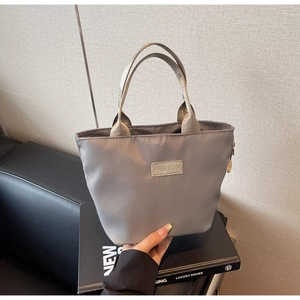 Détail du mini sac cabas gris en nylon avec écusson FASHION et anses en sangle