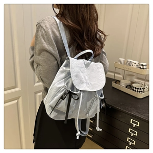 Détail du sac à dos bleu clair avec broderie Nika et cordon en ruban noir