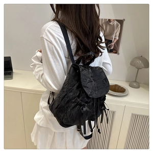 Gros plan du sac à dos noir avec détail de nœud élégant et tissu texturé sur un mannequin