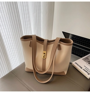 Détail du sac cabas bicolore avec fermoir rotatif doré et garnitures en cuir