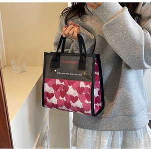 Dettaglio della borsa tote in tela con cuori, pannello trasparente e manici neri robusti