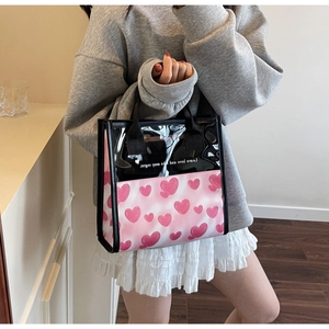 Dettaglio della borsa rosa con stampa a cuori, pannello nero traslucido e manici intrecciati