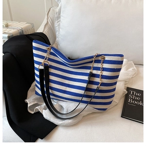 Macro view of blue and white striped tote bag showing durable knit fabric and gold chain straps