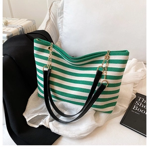 Detail of green and white striped canvas tote bag with chain strap and leather handle