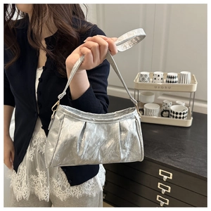 Detailed macro view of silver metallic pleated texture on a stylish underarm bag