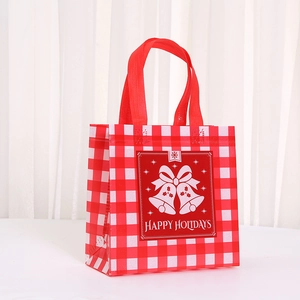 Close-up of Christmas non-woven gift bag with red plaid and Happy Holidays bells