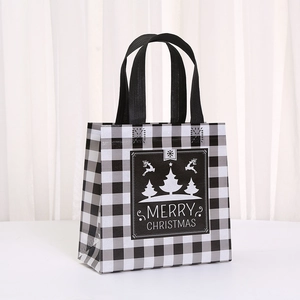 Close-up of Christmas non-woven gift bag with black and white gingham and tree design