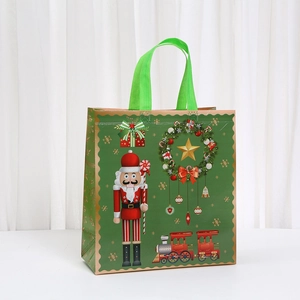 Close-up of green Christmas tote bag featuring nutcracker and steam train prints