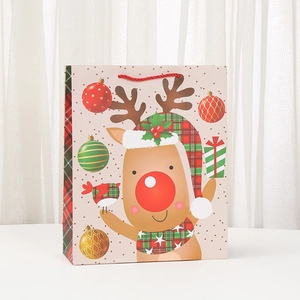 Pink Christmas gift bag with cartoon reindeer and red plaid handles on white display