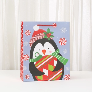 Christmas gift bag featuring a cartoon penguin with holiday decorations on white cardstock