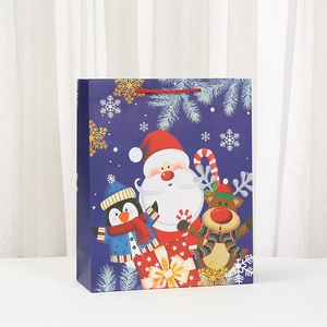 Blue Christmas gift bag featuring Santa, penguin and reindeer icons with red handles