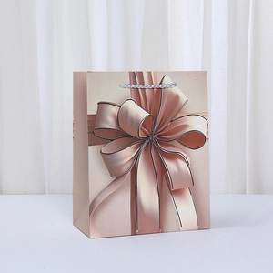 Bolsa de regalo oro champán con estampado de lazo 3D y asas de cuerda trenzada