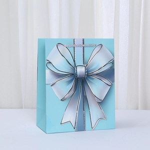 Elegante bolsa de regalo de papel azul claro con un gran lazo blanco 3D para eventos