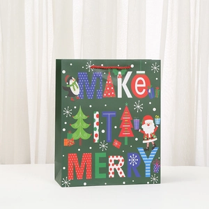 Christmas paper gift bag featuring a green Merry Christmas design with Santa and penguins