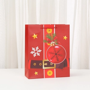 Detail of red Christmas gift bag featuring Santa belt pattern and festive pine accents