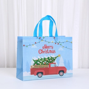 Blue waterproof non-woven Christmas gift bag with red truck and festive tree print