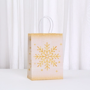 Detail of cream gift bag featuring golden snowflake patterns and woven rope handles